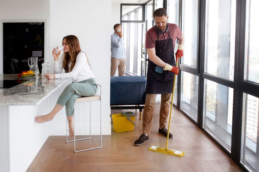Cleaner mopping hardwood floor in modern apartment during end of lease cleaning in Perth by NewTouch Cleaning